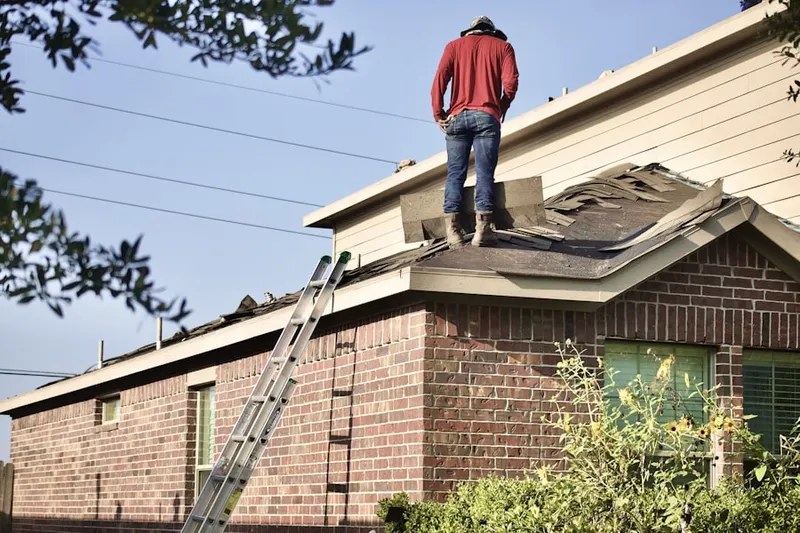 Professional roofer working on a residential roof in Newfield